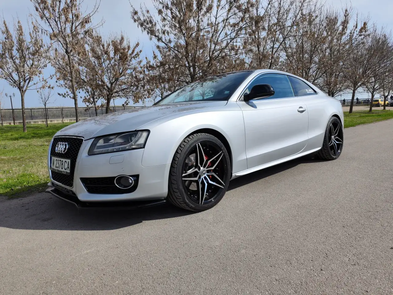 Srebrne auto z felgami w r&oacute;żnych kolorach