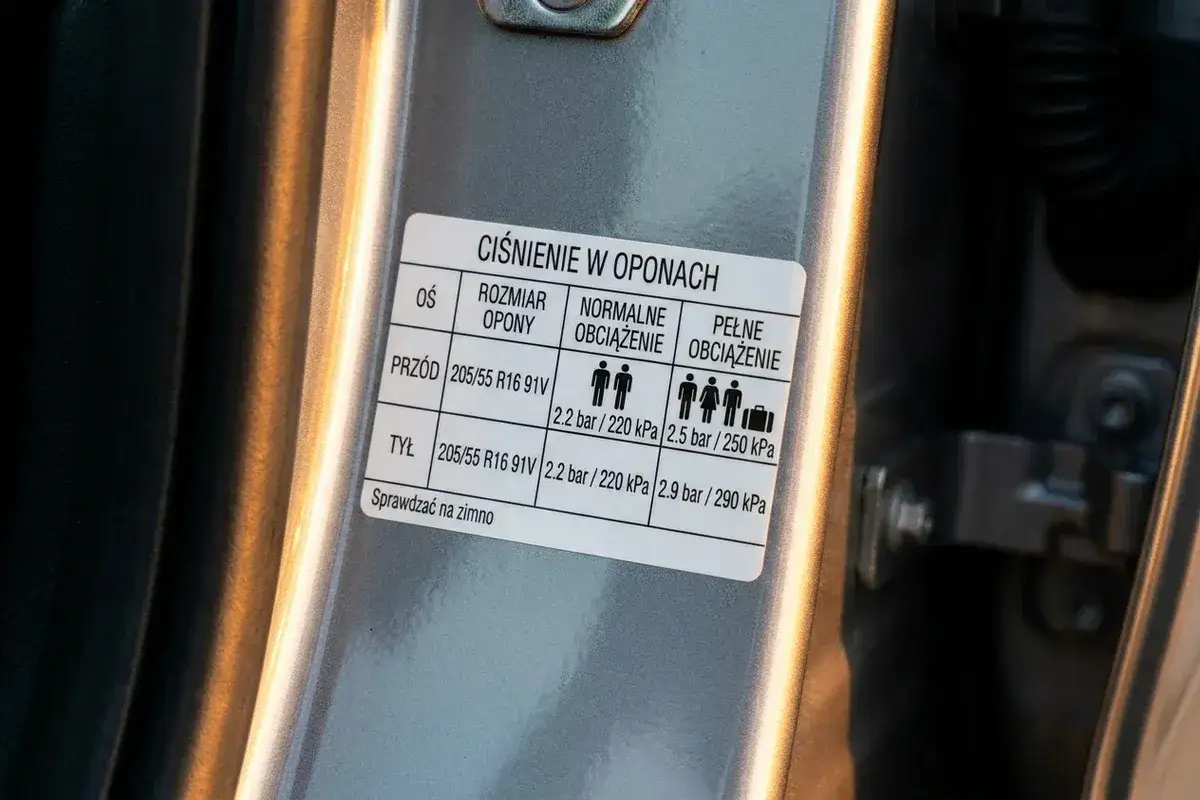 Naklejka informuje, jakie ciśnienie w oponach jest zalecane dla różnych obciążeń. Podane są wartości dla przodu i tyłu pojazdu.